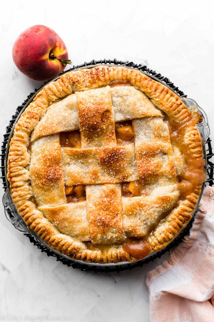 an apple pie on a white table with a pink napkin