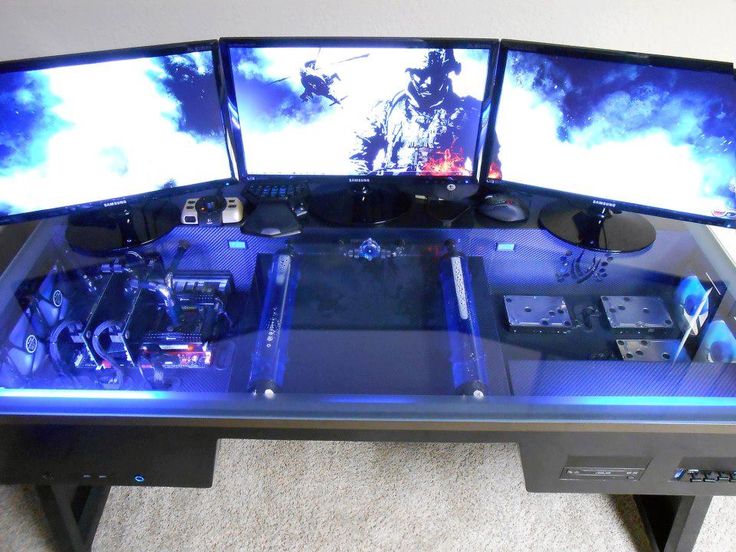 three computer monitors sitting on top of a table