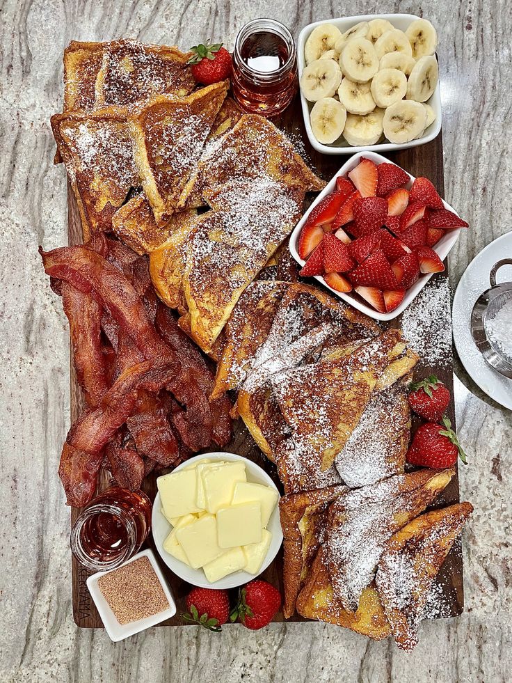 the breakfast platter includes french toast, strawberries, bananas, and other fruit