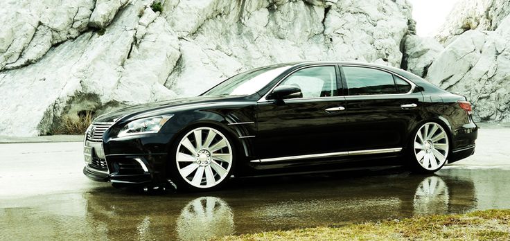 a black car parked in front of a mountain