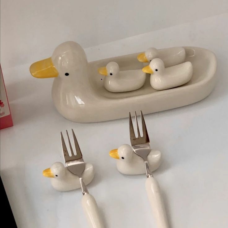 a group of forks and spoons sitting on top of a table with ducks in it