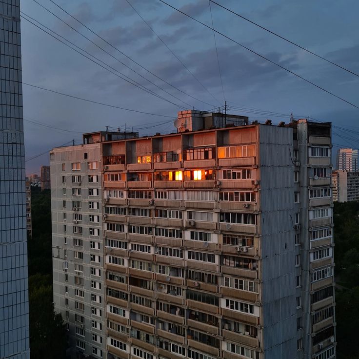 an apartment building with many windows and balconies in the evening time, as seen from above