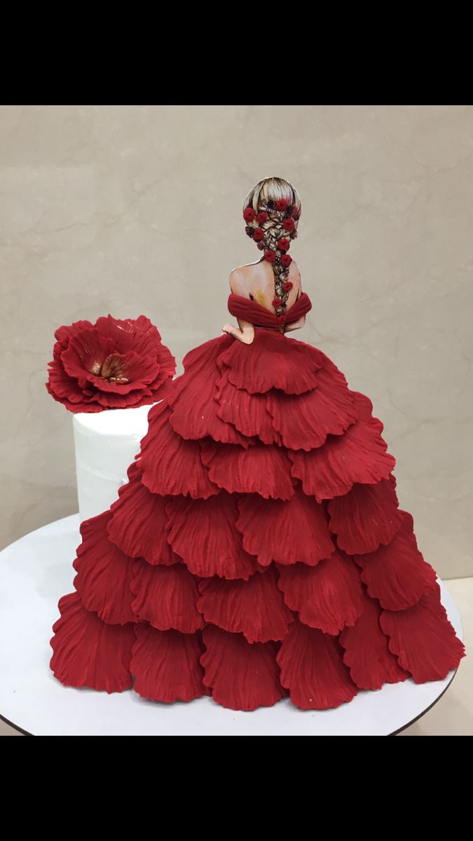 a red dress is on top of a white cake