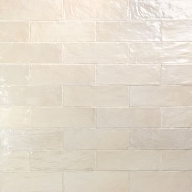 a white toilet sitting next to a tiled wall