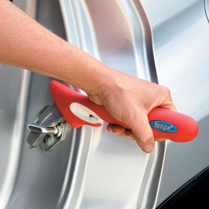 a hand is opening the door to a car with a red handle and white wheels