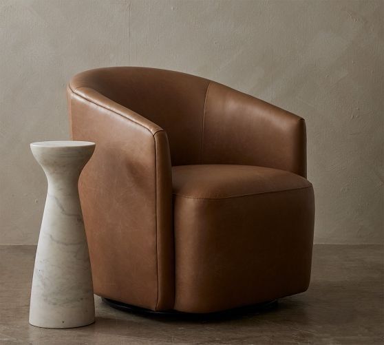 a brown leather chair sitting next to a white vase