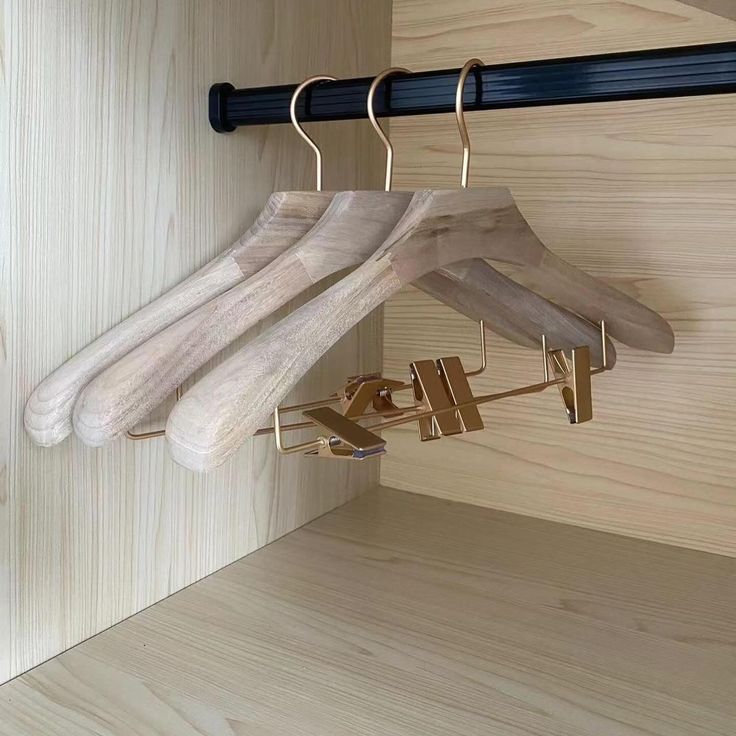 clothes hangers are hanging on a wooden wall