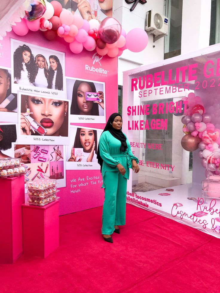 a woman standing in front of a pink display