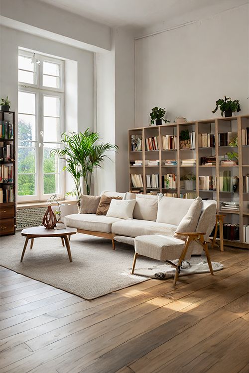 a living room filled with furniture and bookshelves next to a large open window