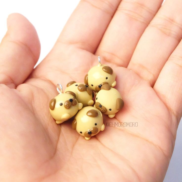 five little bears are sitting in the palm of someone's hand and one is wearing a necklace