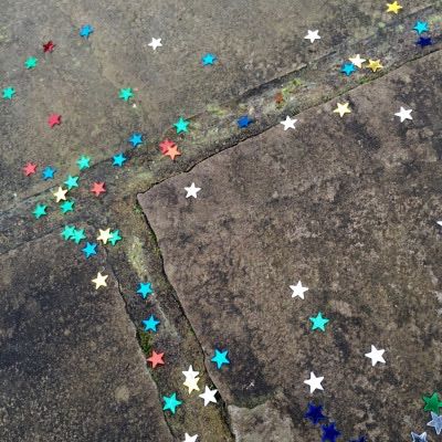 an aerial view of colorful stars on the ground in front of a street with no cars