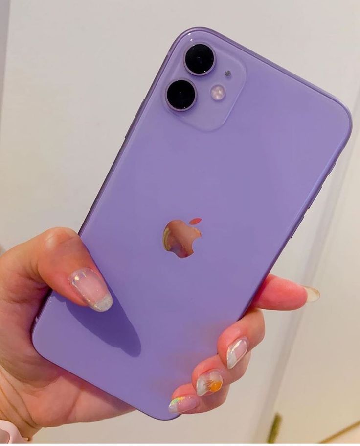 a woman's hand holding up a purple phone case with an apple logo on it