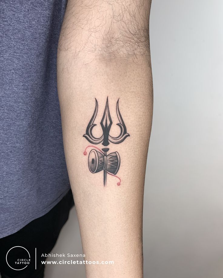 a tattoo on the arm of a man with an open book and devil's horns