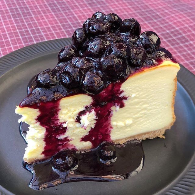 a piece of cheesecake on a plate with blueberries