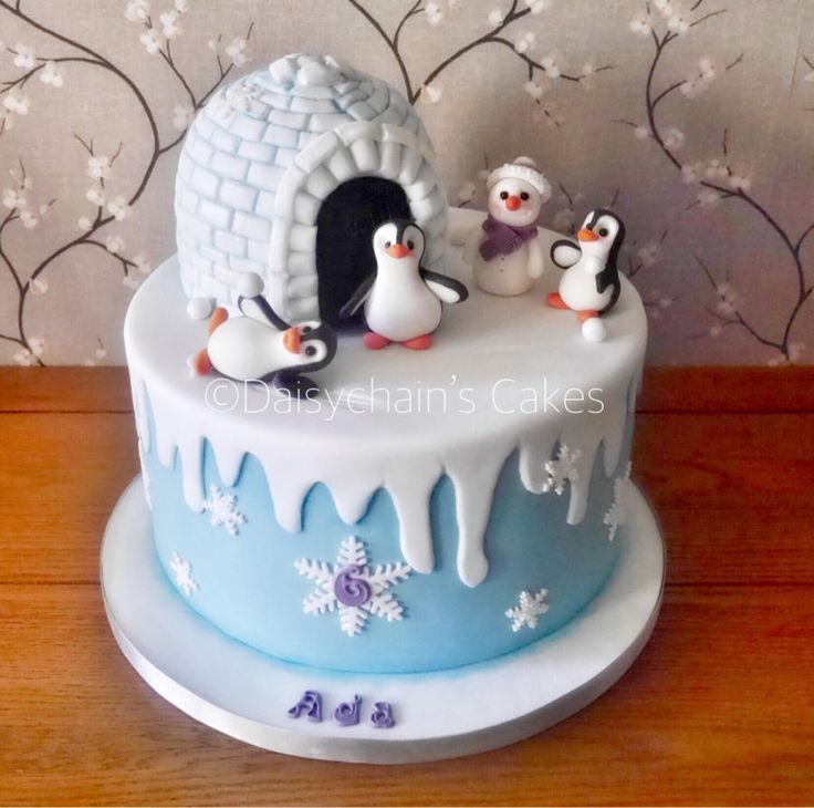 a birthday cake with penguins and an igloo