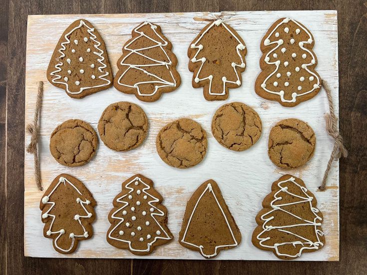 a wooden board topped with lots of cut out christmas trees and gingerbread cookies on top of each other