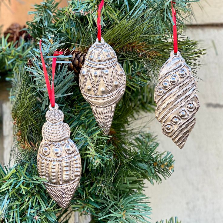 three ornaments hanging from a christmas tree