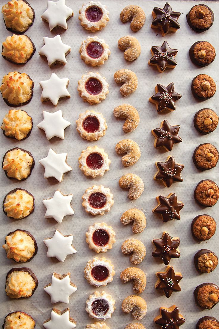 an assortment of cookies and pastries arranged on a sheet of wax paper with stars