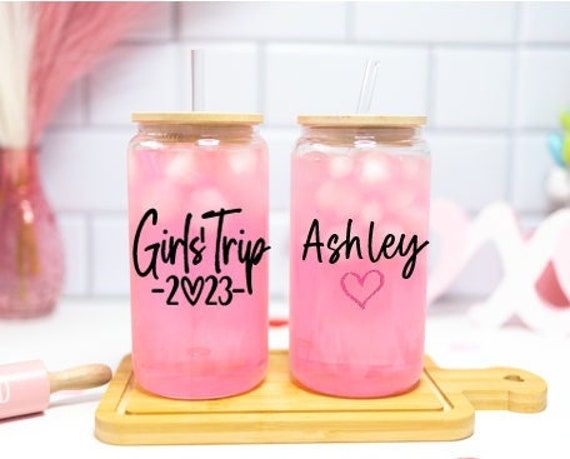 two pink mason jars sitting on top of a wooden tray