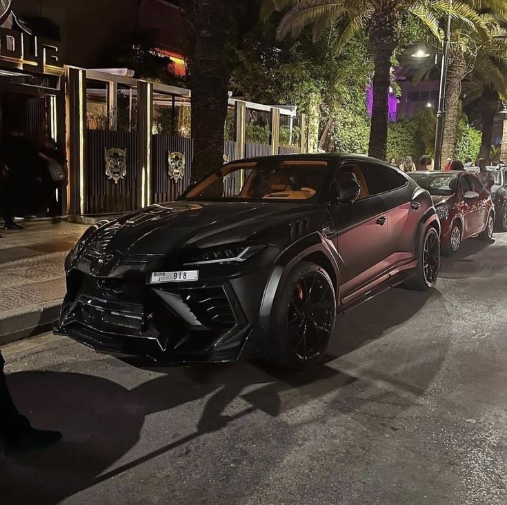 the cars are parked on the side of the road in front of some palm trees