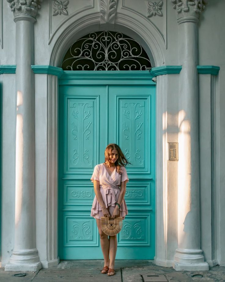 a woman standing in front of a blue door