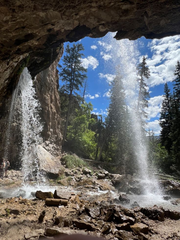 there is a waterfall coming out of the cave