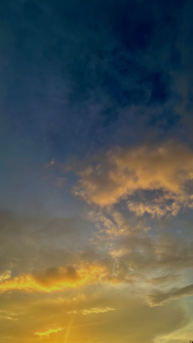 an airplane flying in the sky at sunset