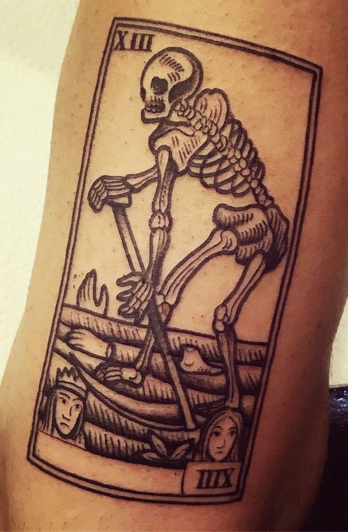 a skeleton playing card tattoo on the leg