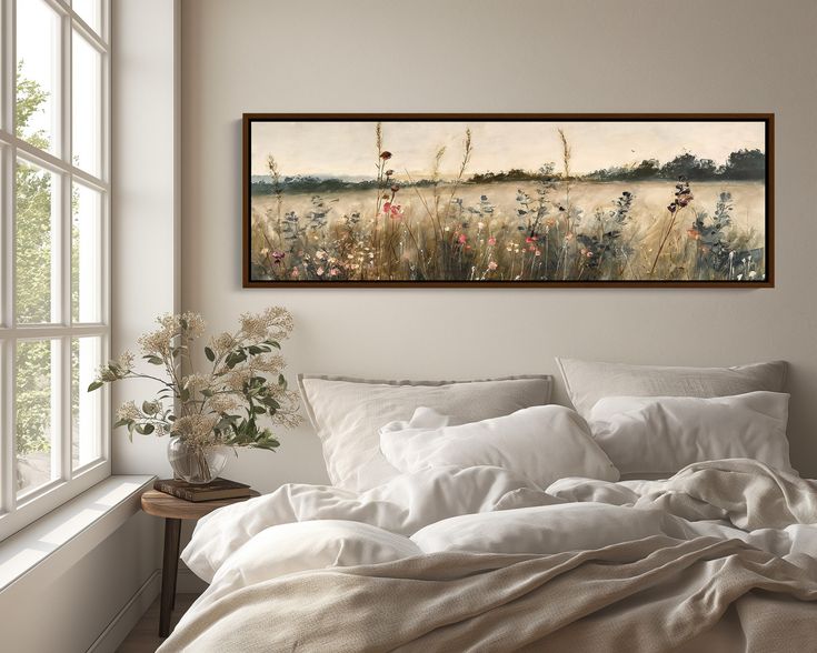 a painting hanging above a bed in a bedroom