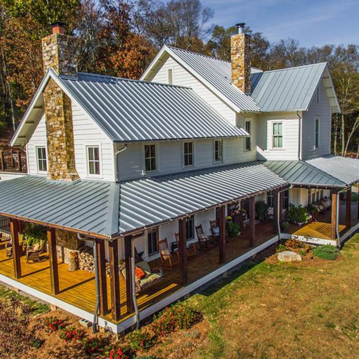 an aerial view of a house in the fall with lots of windows and covered porches