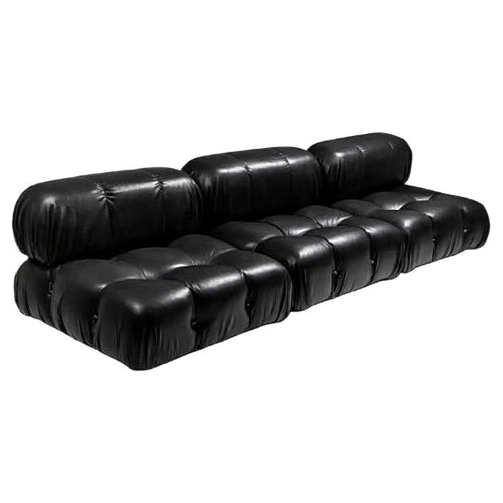 a black leather couch sitting on top of a white floor