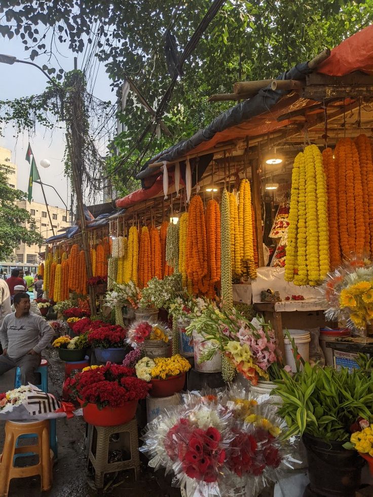 an outdoor market with many different types of flowers