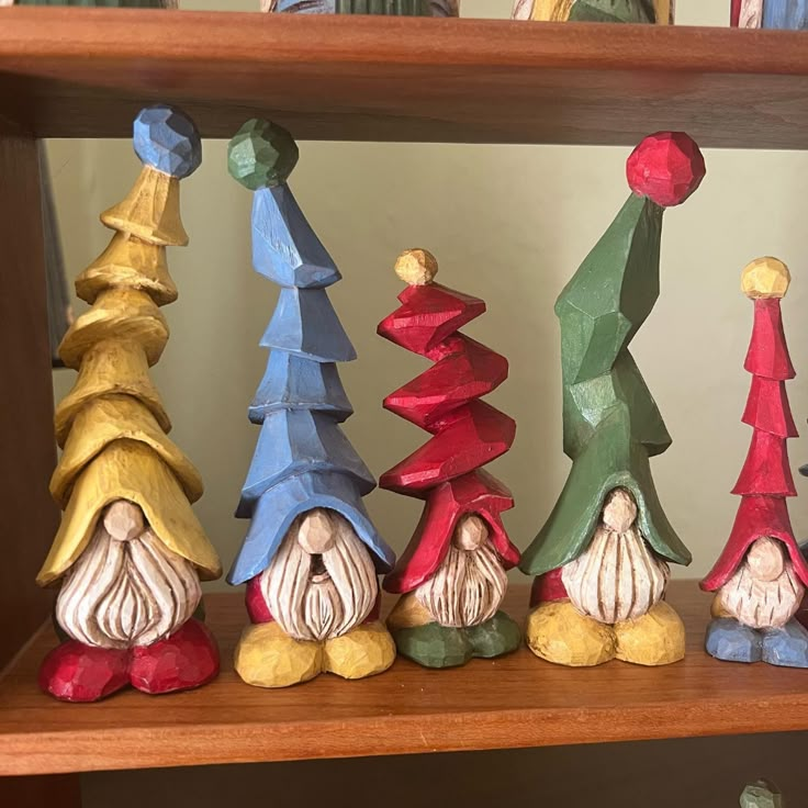 small wooden gnomes are lined up on a shelf