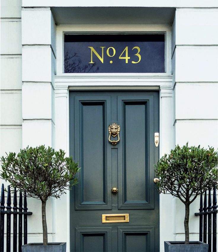 a green door with two planters on either side and no 43 sign above it