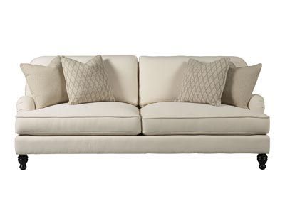 a white couch with some pillows on it's back and one pillow in the middle