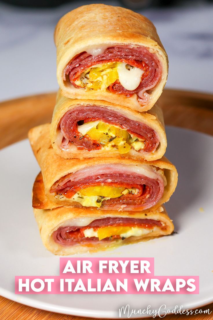 three ham and cheese wrapped in bread on a white plate with the words air fryer hot italian wraps