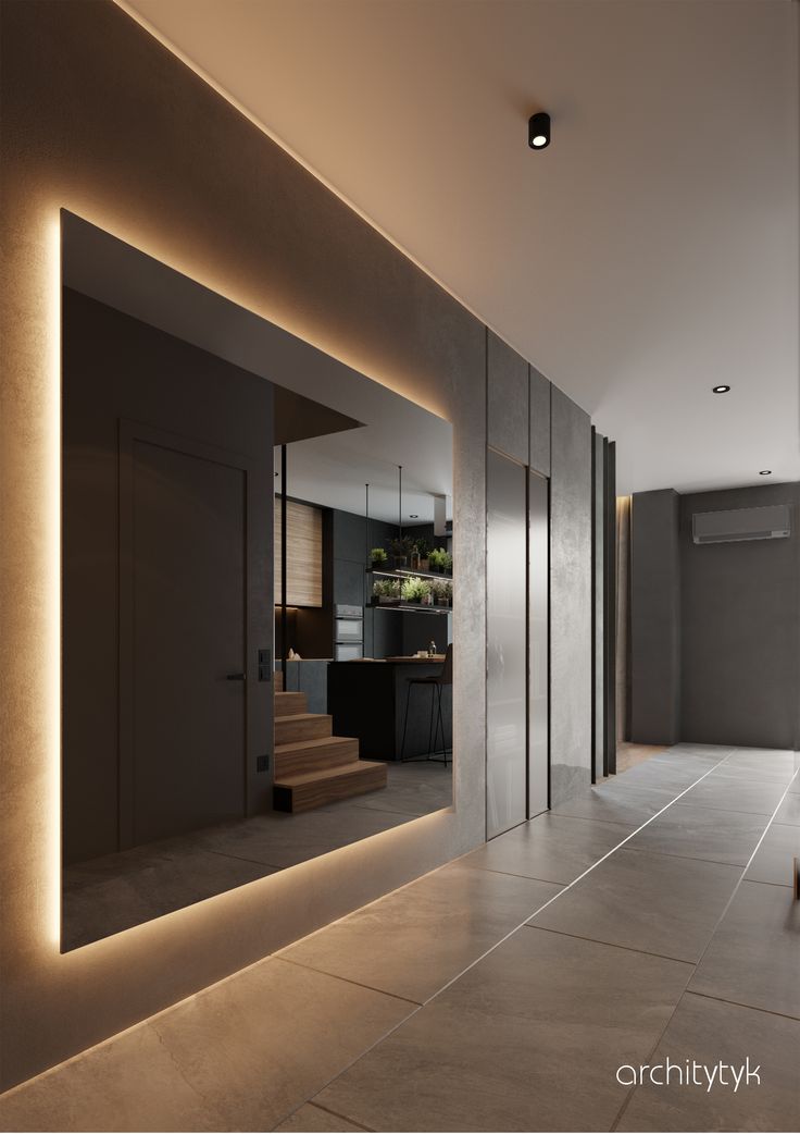 an empty room with some lights on the wall and stairs leading up to the kitchen