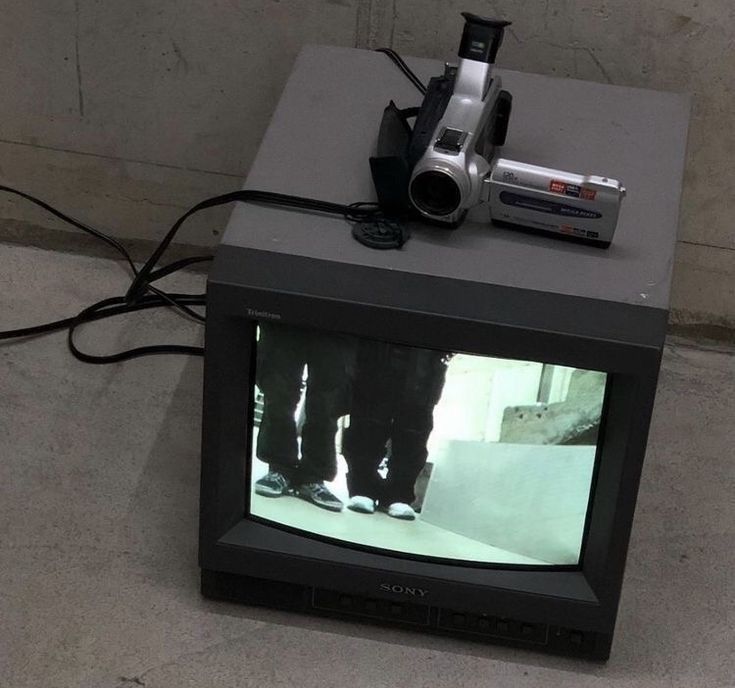 an old television sitting on top of a box with a camera attached to the tv