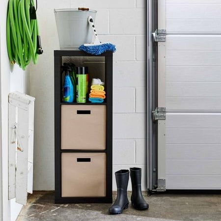 a tall shelf with two bins on top of it next to a pair of rubber boots