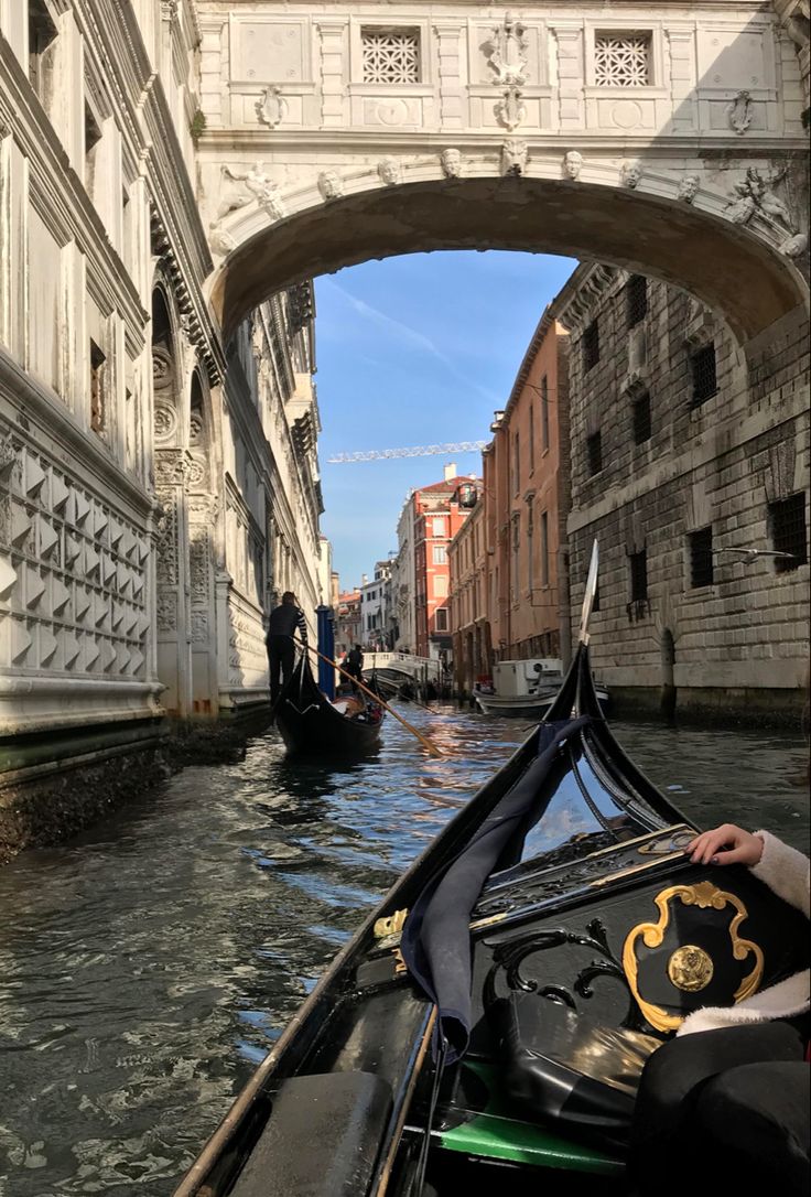 a gondola is going under an overpass on a canal in venice, italy