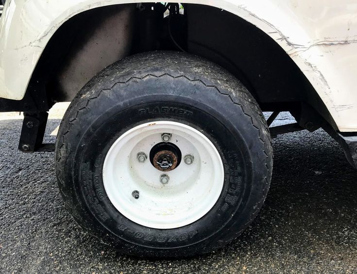 the front wheel of a white pickup truck