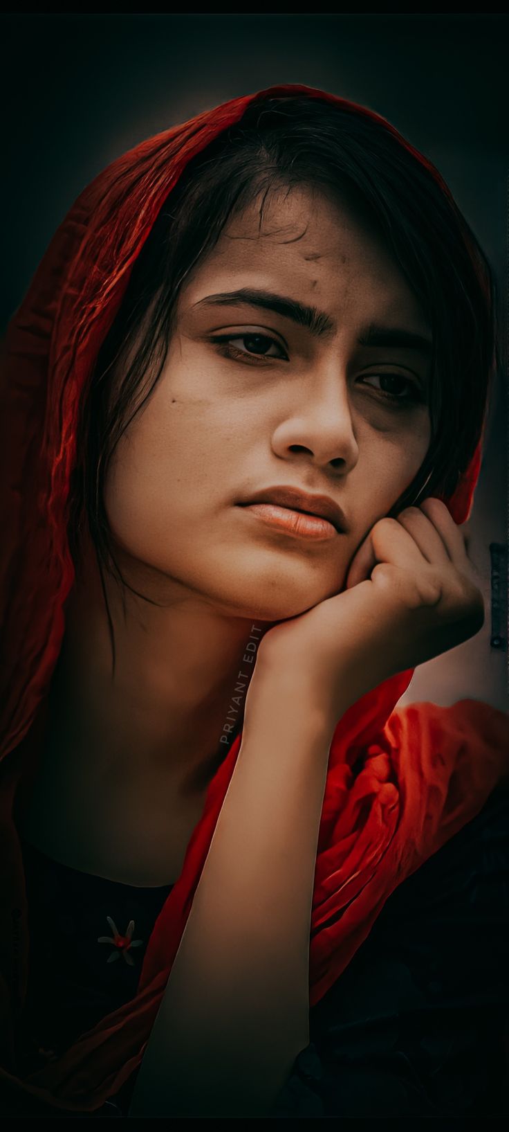 a woman with a red scarf on her head and hand under her chin looking at the camera