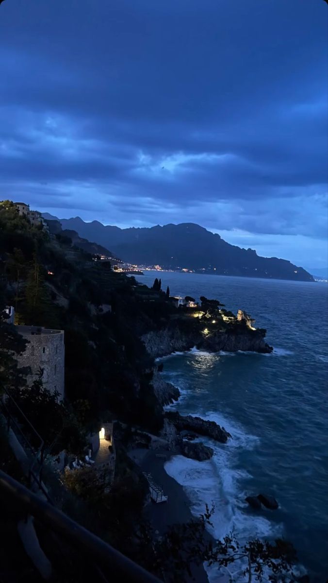 the ocean is lit up at night with lights on