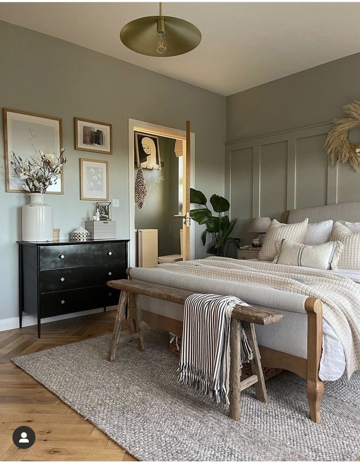 a bedroom with a bed, dresser and pictures on the wall