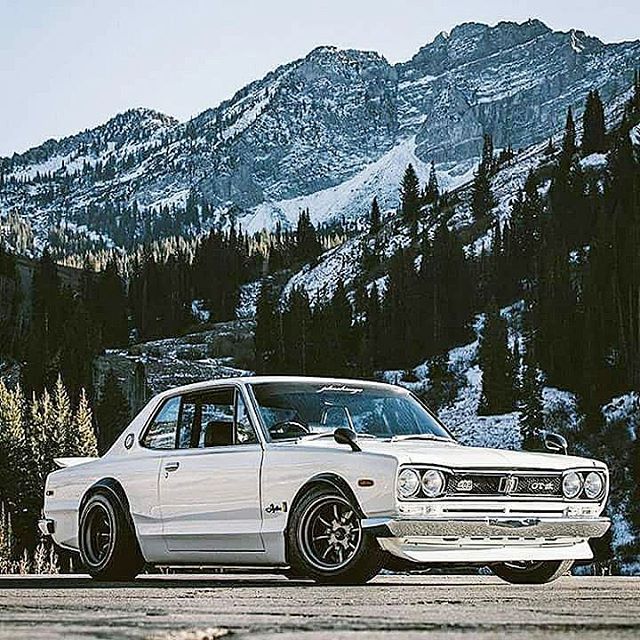 a white car parked in front of a mountain