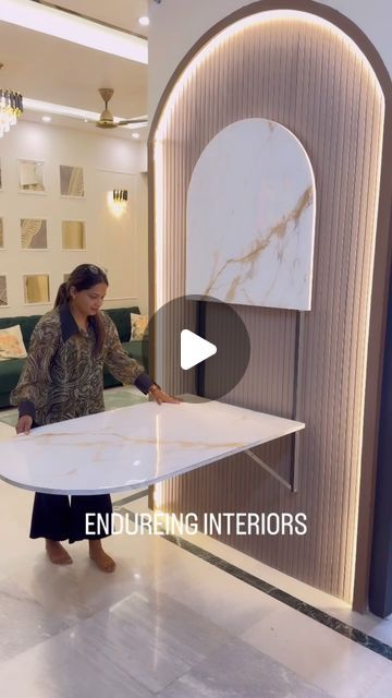 a woman holding a surfboard in front of a room with marble walls and flooring