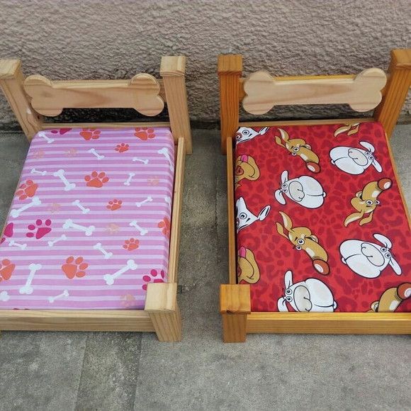 two children's wooden beds with dog prints on them, one is pink and the other is red