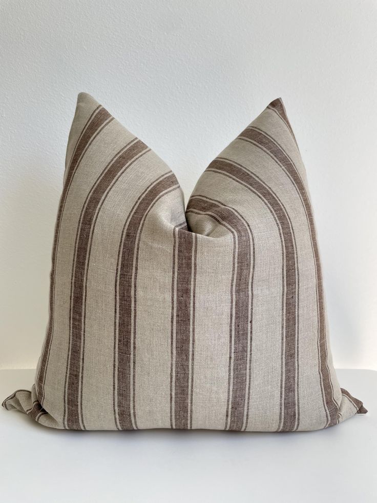 a brown and white striped pillow sitting on top of a table