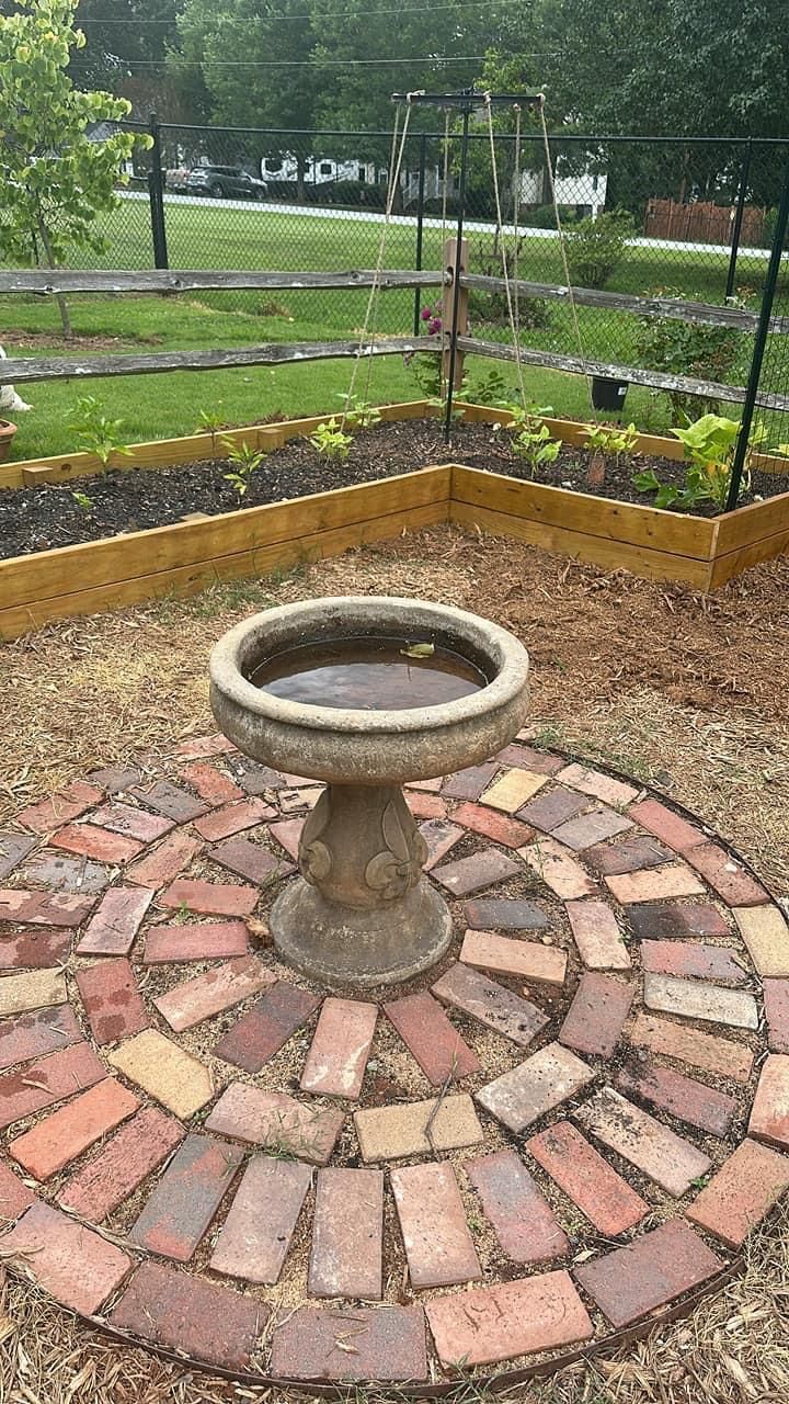 a stone fountain in the middle of a garden