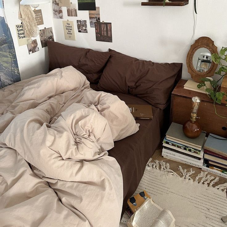 an unmade bed sitting in a bedroom next to a wooden dresser and clock on the wall